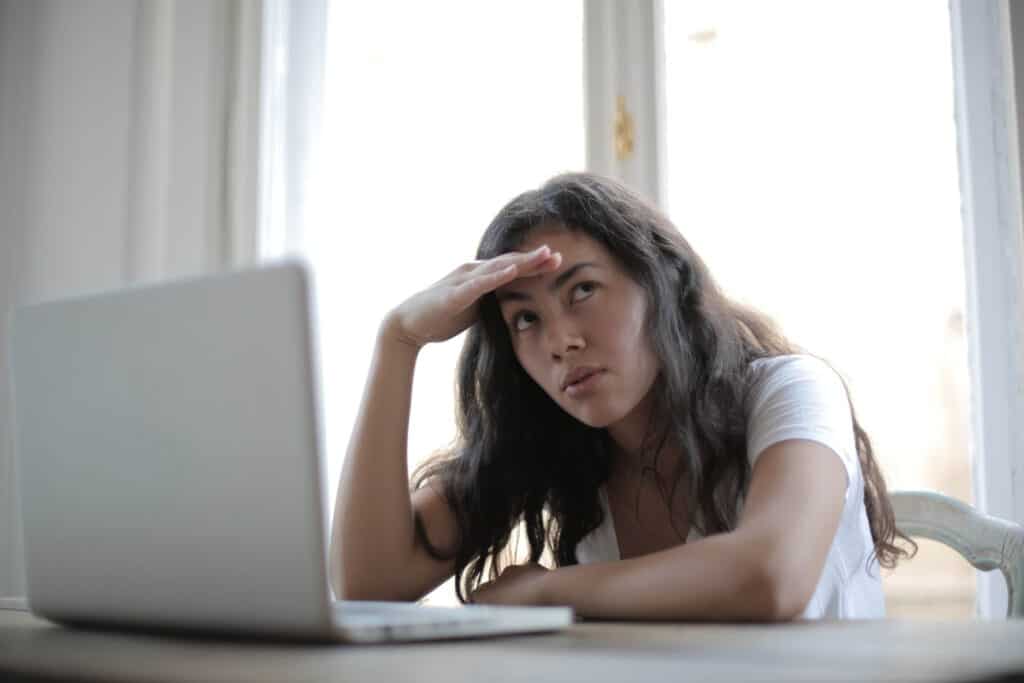 Woman looking away from her laptop