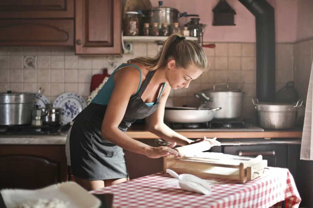 Woman rolling dough in kitchen